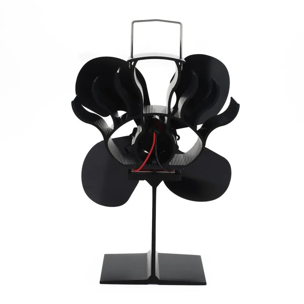 Black thermodynamic fireplace fan with Yotsuba style blades, placed on a fireplace surface
