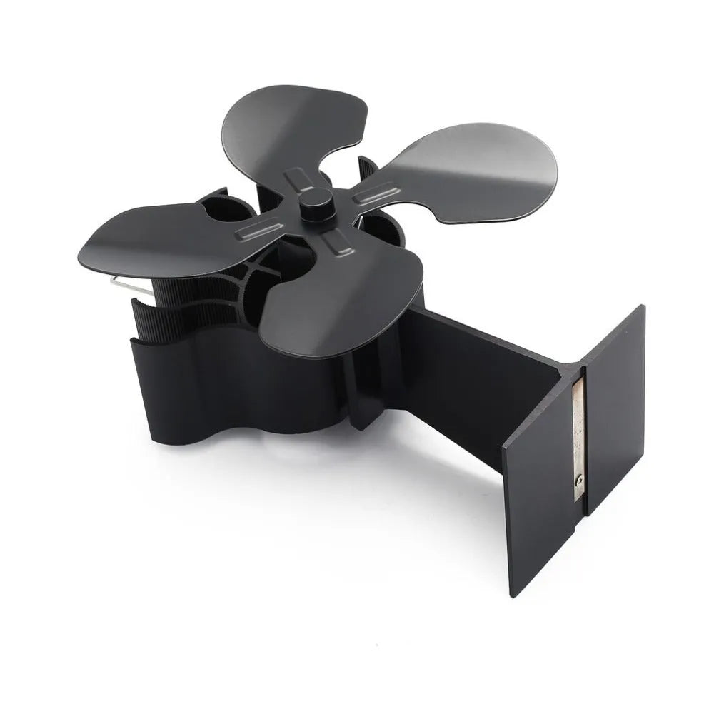 Black thermodynamic fireplace fan with Yotsuba style blades, placed on a fireplace surface
