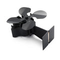 Black thermodynamic fireplace fan with Yotsuba style blades, placed on a fireplace surface