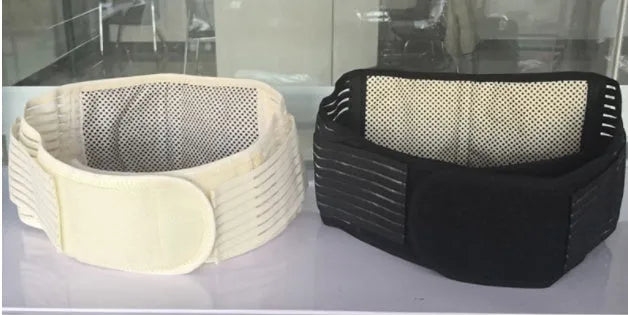 Black self-heating magnetic waist support belt fastened around a waist, showing adjustable straps and elastic cloth material.