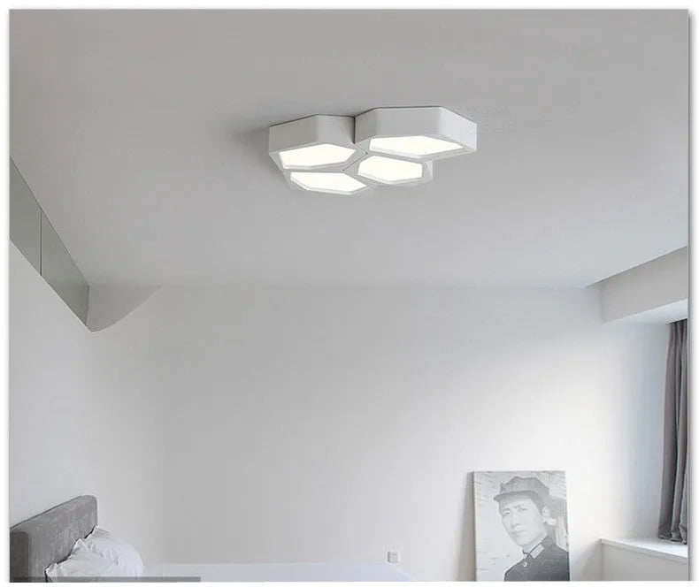 Modern geometric-shaped iron wall light with remote control on a living room wall.
