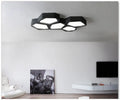 Modern geometric-shaped iron wall light with remote control on a living room wall.