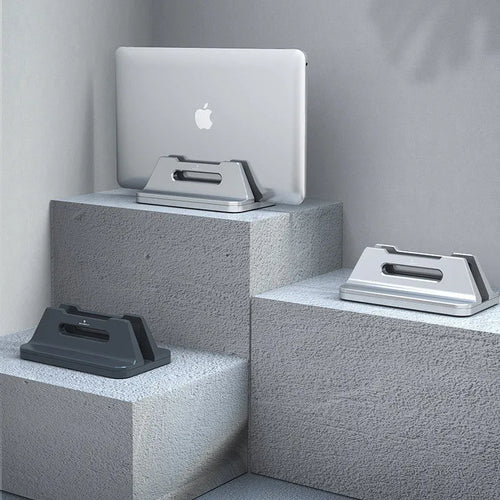 Silver aluminium alloy vertical notebook storage bracket on desk holding a laptop upright