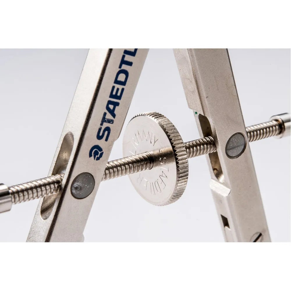 STAEDTLER steel car drafting compass with extended telescopic rod on technical drawing paper.