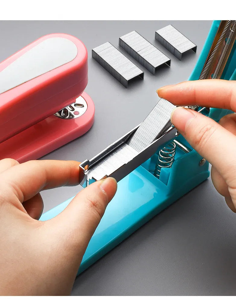 Black 360-degree rotatable stapler on a stack of A4 paper, showing its rotating head mechanism.