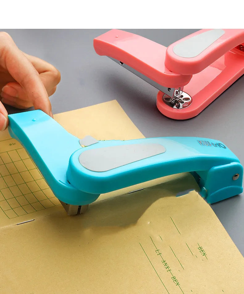Black 360-degree rotatable stapler on a stack of A4 paper, showing its rotating head mechanism.