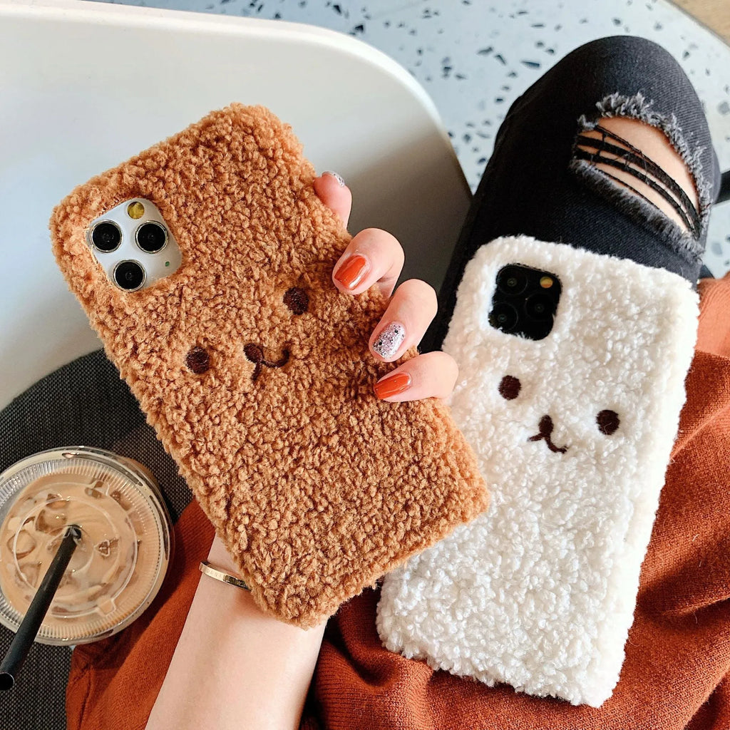 Brown embroidered plush cartoon bear face on a clear TPU iPhone 11 case, showing raised edges.