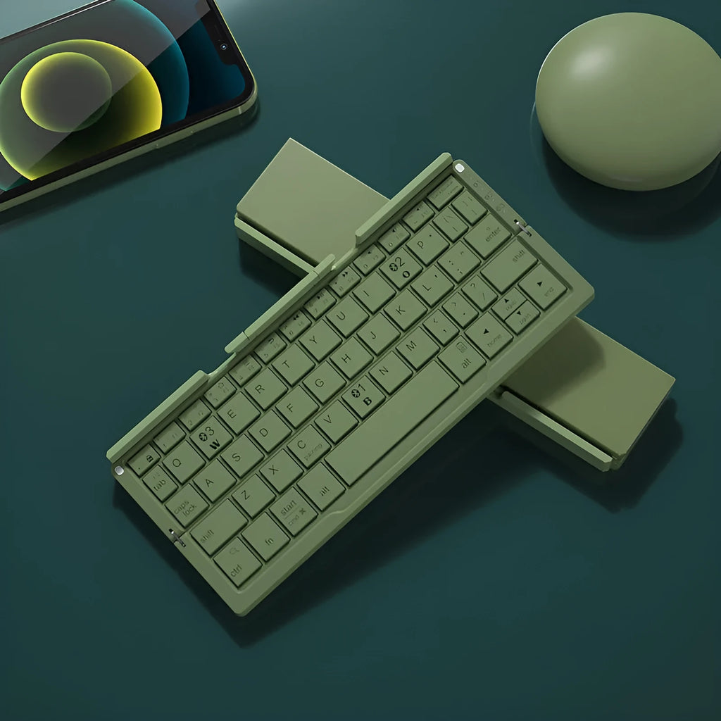 Silver white aluminium folding Bluetooth keyboard shown open next to a smartphone propped on its hidden stand.