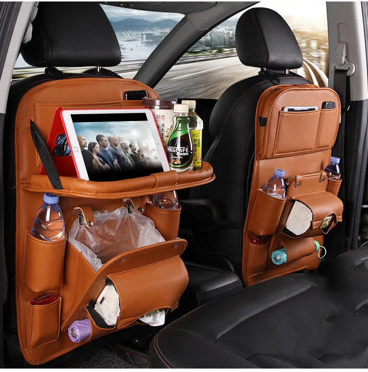 Black PU leather car seat back hanging organiser with storage pockets and a removable bin attached to a car headrest.