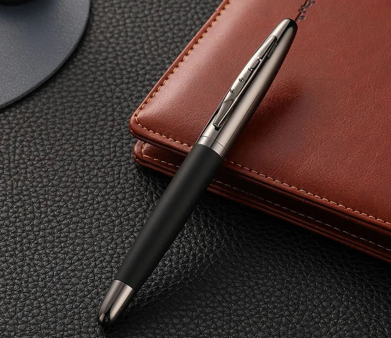 Heavy metal signature pen with non-slip grip and blue ink refill on a desk surface