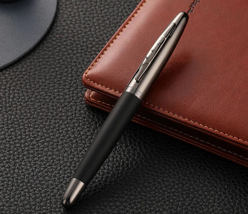 Heavy metal signature pen with non-slip grip and blue ink refill on a desk surface