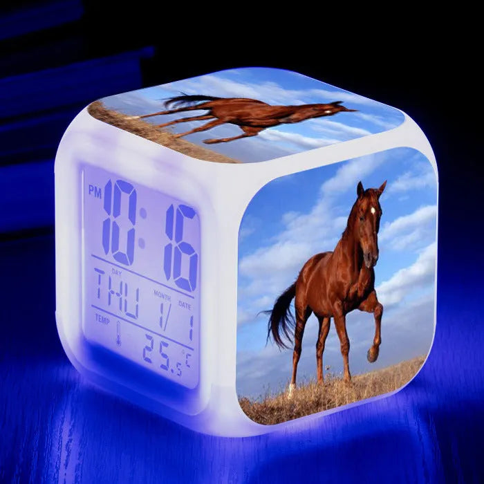 Square cartoon-style LED alarm clock showing digital time display with colour-changing illumination