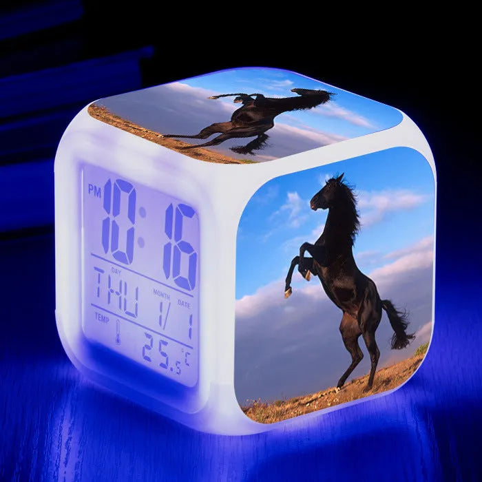 Square cartoon-style LED alarm clock showing digital time display with colour-changing illumination