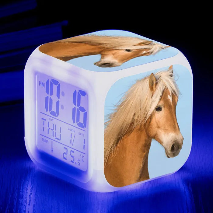 Square cartoon-style LED alarm clock showing digital time display with colour-changing illumination