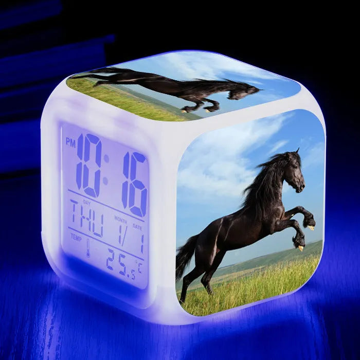 Square cartoon-style LED alarm clock showing digital time display with colour-changing illumination