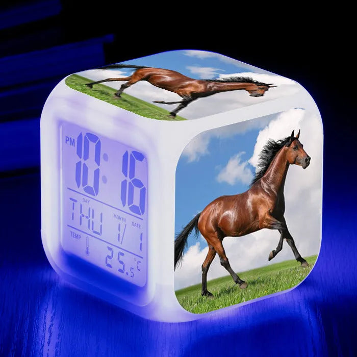 Square cartoon-style LED alarm clock showing digital time display with colour-changing illumination