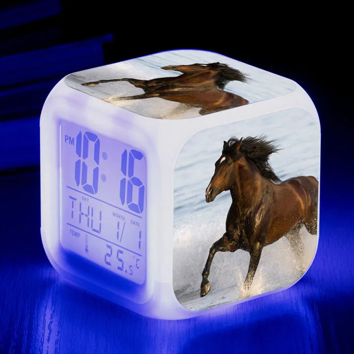 Square cartoon-style LED alarm clock showing digital time display with colour-changing illumination