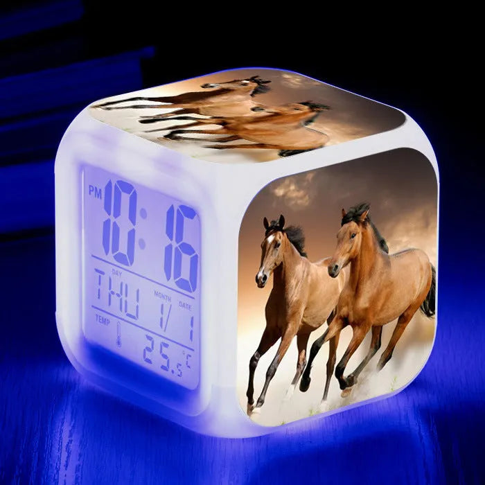 Square cartoon-style LED alarm clock showing digital time display with colour-changing illumination