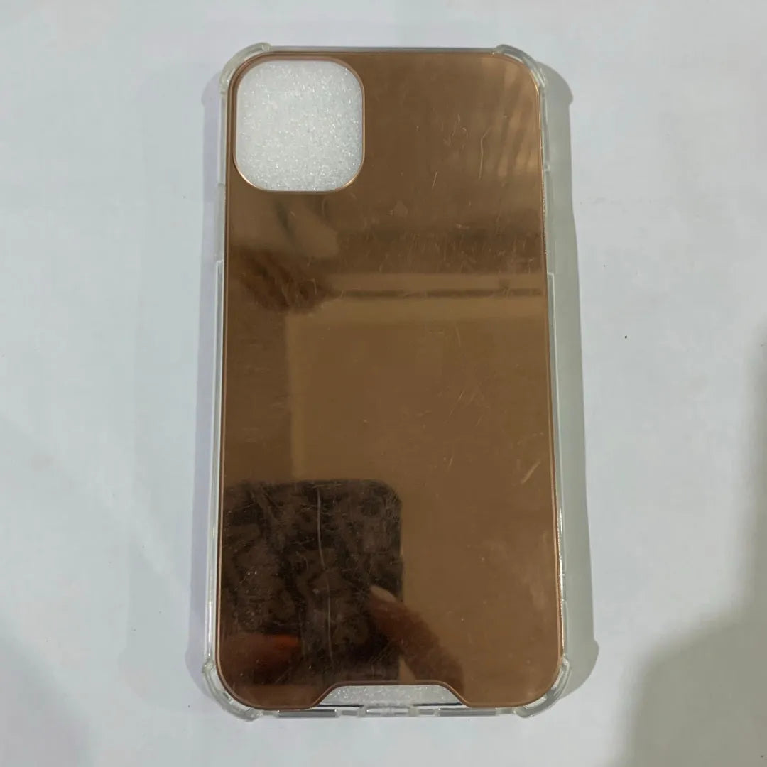 TPU mirror phone case for iPhone on a table, showing anti-fingerprint finish.