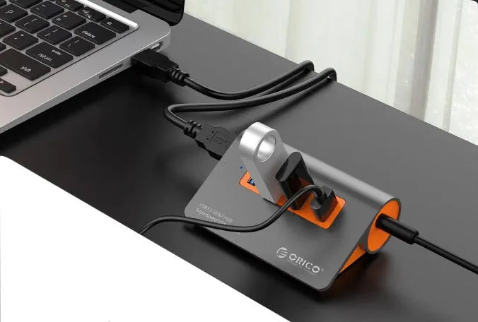 Dark grey and orange aluminium USB-C hub with four USB 3.1 ports and separate 100 cm cable