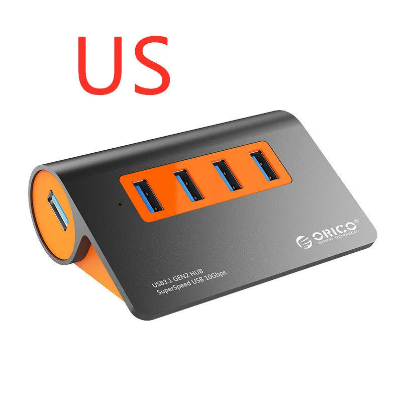 Dark grey and orange aluminium USB C hub with four USB 3.1 ports and a long black data cable.