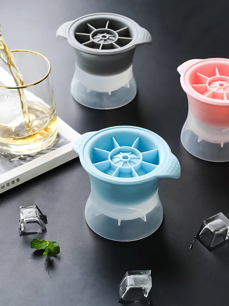 Flexible silicone ice tray showing large hockey puck and spherical ice cube moulds in pastel colours.