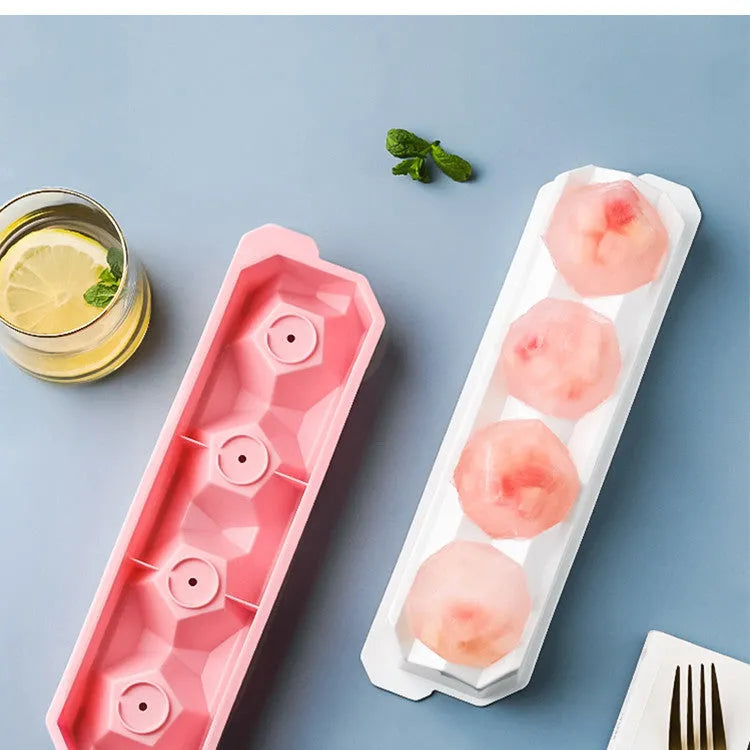 Flexible silicone ice tray showing large hockey puck and spherical ice cube moulds in pastel colours.