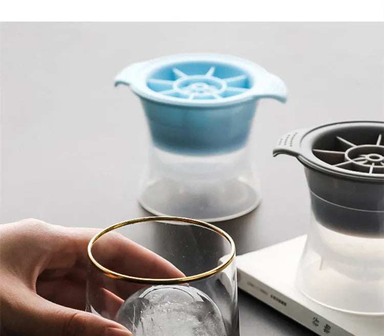 Flexible silicone ice tray showing large hockey puck and spherical ice cube moulds in pastel colours.