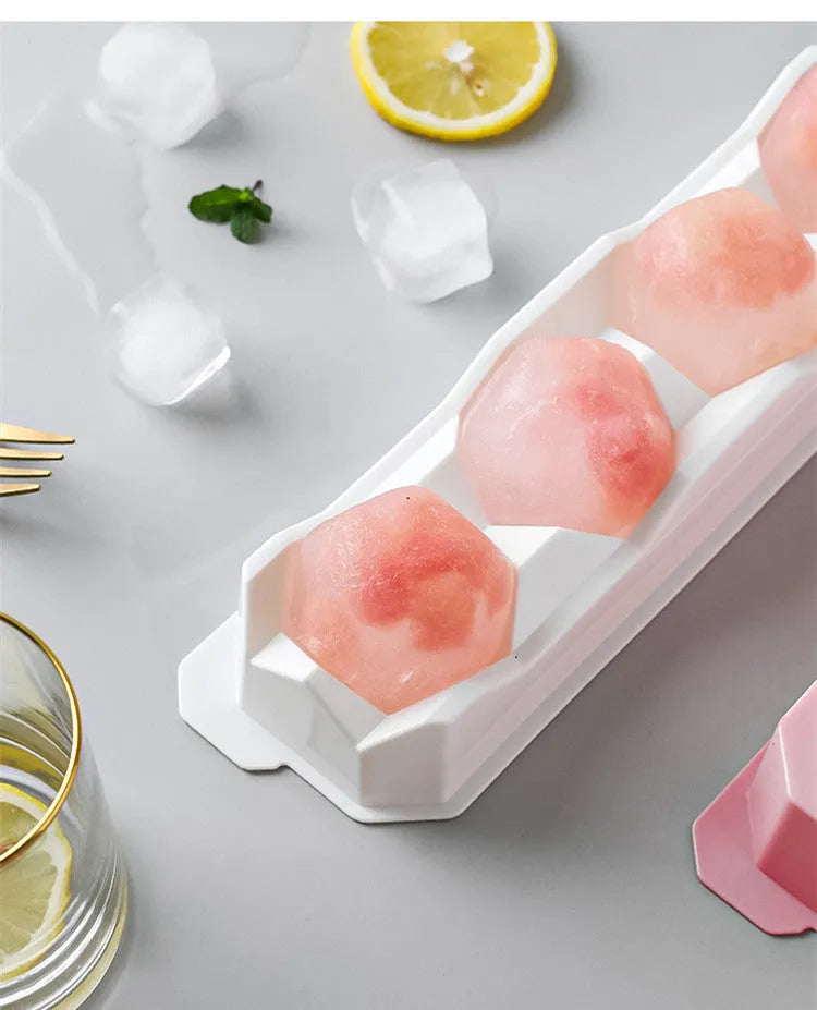 Flexible silicone ice tray showing large hockey puck and spherical ice cube moulds in pastel colours.