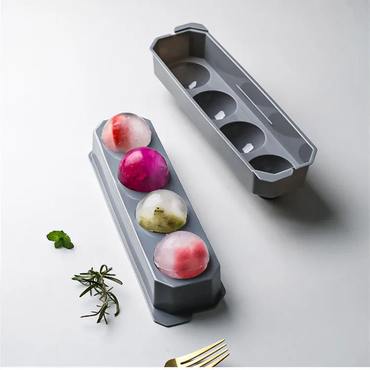 Flexible silicone ice tray showing large hockey puck and spherical ice cube moulds in pastel colours.