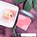 Pink self-adhesive plastic packaging bags with UV printing, shown sealed and open, next to a bar of soap.