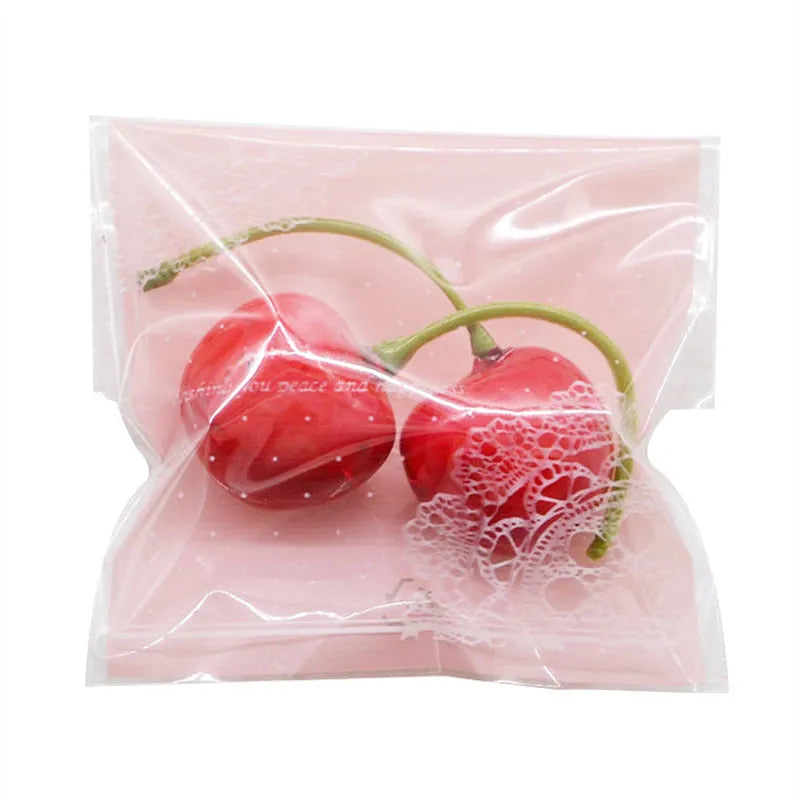 Pink self-adhesive plastic packaging bags with UV printing, shown sealed and open, next to a bar of soap.