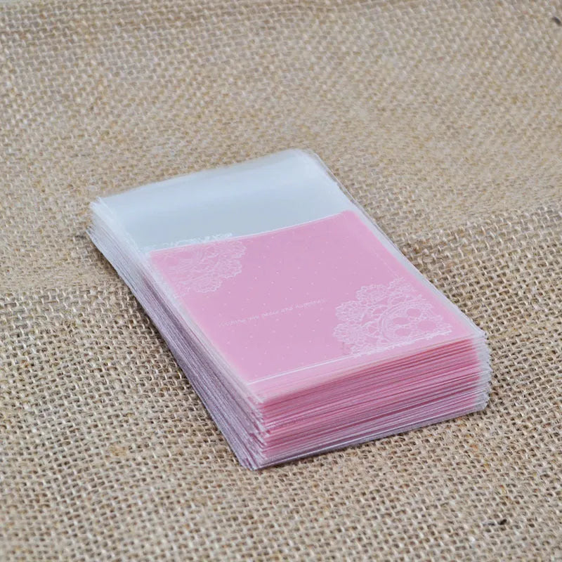 Pink self-adhesive plastic packaging bags with UV printing, shown sealed and open, next to a bar of soap.
