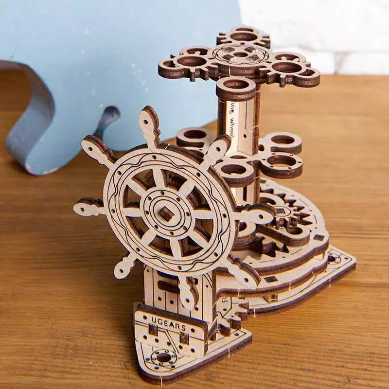 Ukrainian wooden machinery model pen holder with rotating base and four slots for pens on a desk.