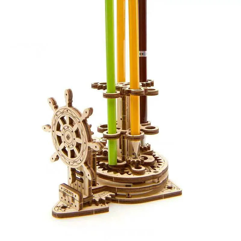 Ukrainian wooden machinery model pen holder with rotating base and four slots for pens on a desk.