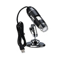 Black plastic portable 1000-times digital microscope with USB cable and 8 LED lights lying on a white surface