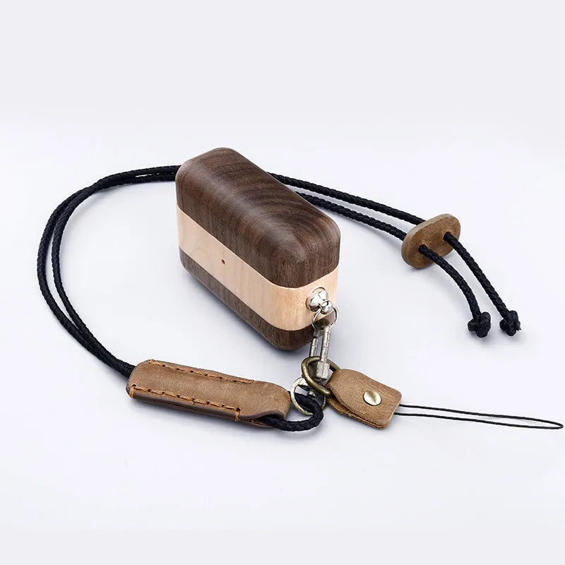 Solid walnut and bamboo wood sleeves for Bluetooth earphones on a wooden table.