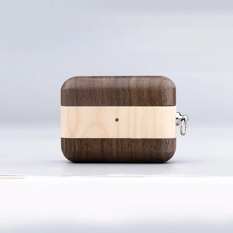 Solid walnut and bamboo wood sleeves for Bluetooth earphones on a wooden table.