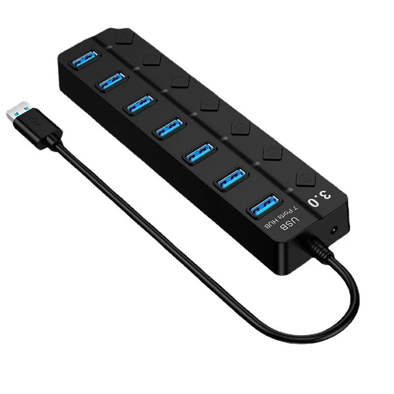 Black 7-port USB 3.0 hub with external power adapter on a wooden desk