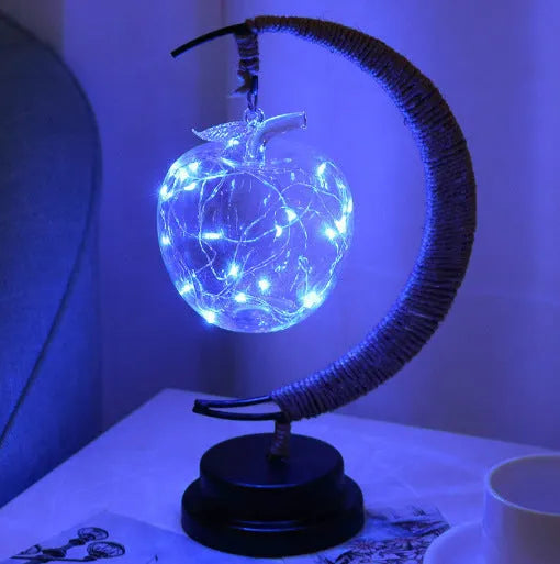 Warm white dimmable LED modelling light in apple shape with 10 beads on a wooden table