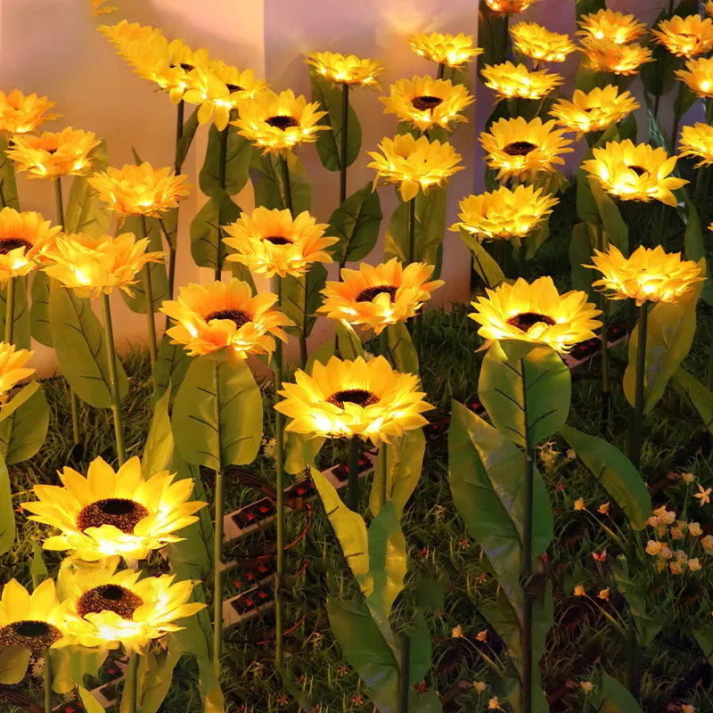LED solar sunflower lamp with yellow fabric flower head, 66cm stainless steel stem, and ABS ground plug, placed on grass