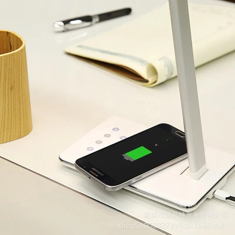 Black wireless charging LED desk lamp with touch control on a wooden desk