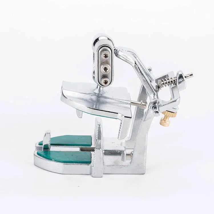 Korean-style adjustable dental articulator with incisal pins on a workbench.