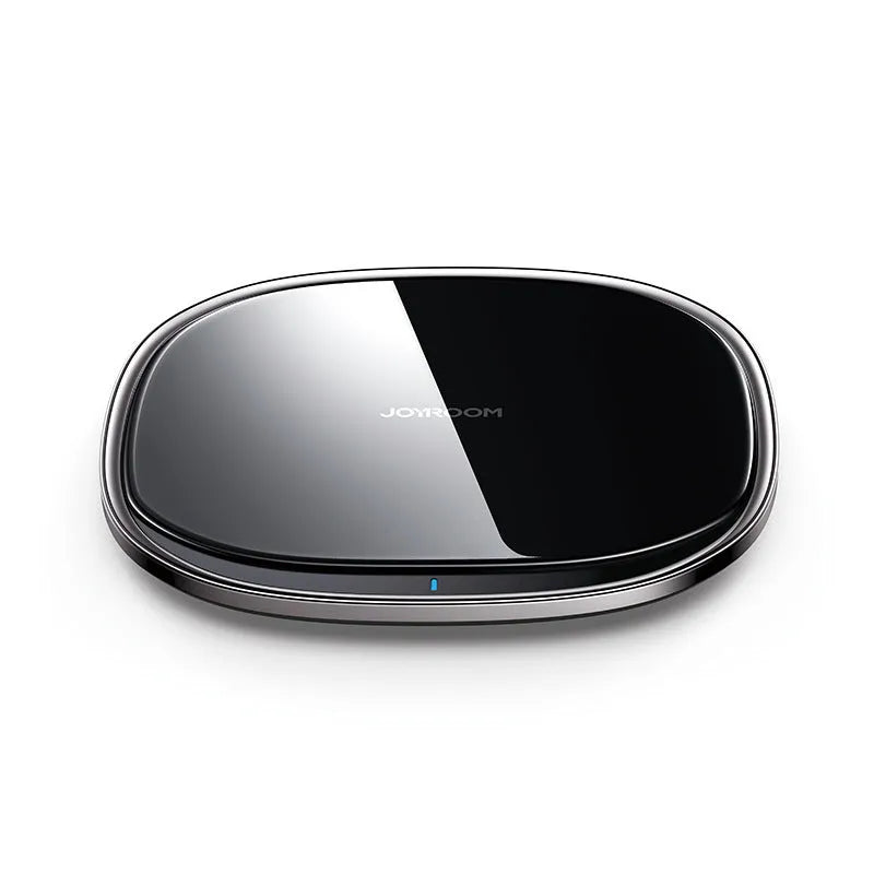 Black square wireless charging pad with glass top and zinc alloy rim on a wooden desk