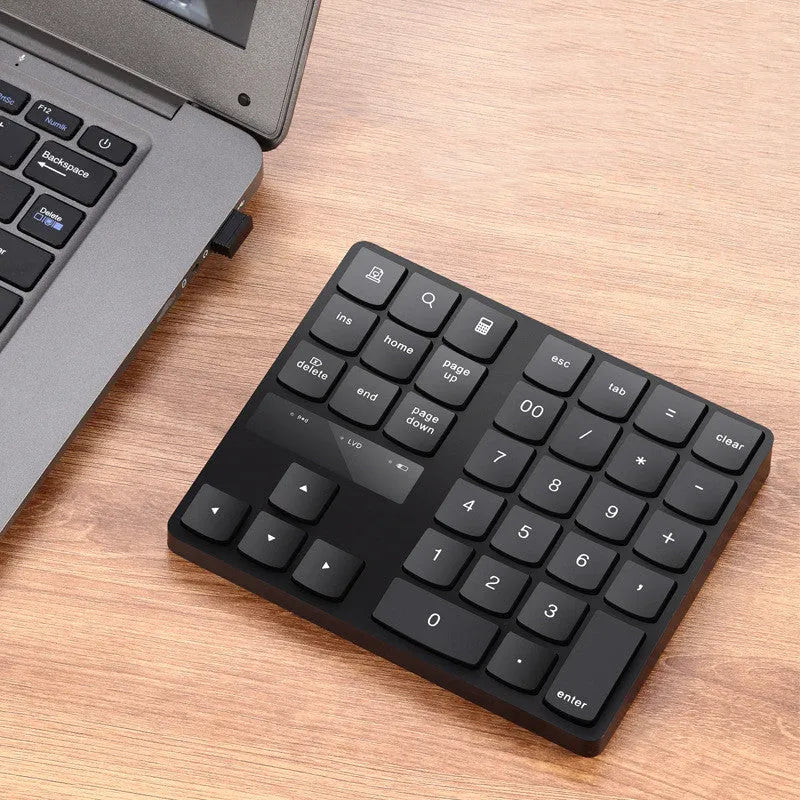 Black wireless numeric keyboard with 35 keys, ABS construction, 145x120x19mm dimensions, USB charging cable and receiver visible