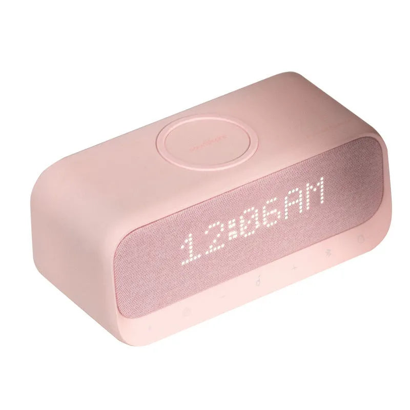 White Anker Soundcore Bluetooth speaker with wireless charging top and digital clock display.