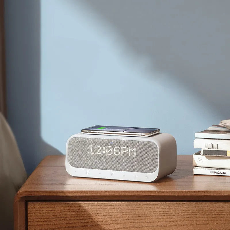 White Anker Soundcore Bluetooth speaker with wireless charging top and digital clock display.