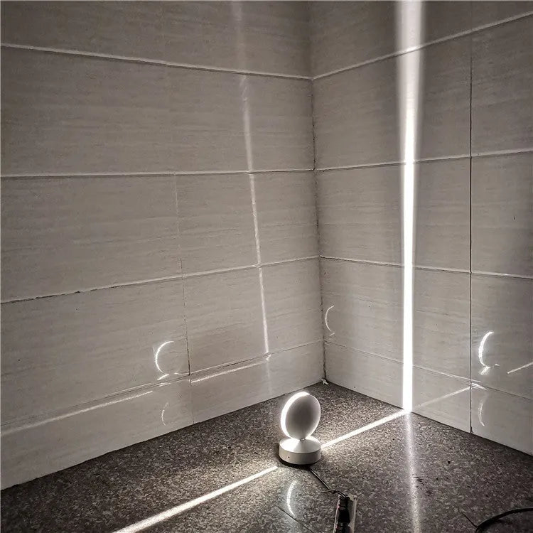 Modern aluminium LED bar wall lamp with glass lens, shown in a corridor setting.