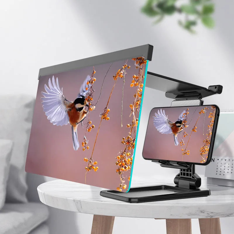 Black foldable mobile phone screen magnifier with detachable phone holder shown on a desktop.