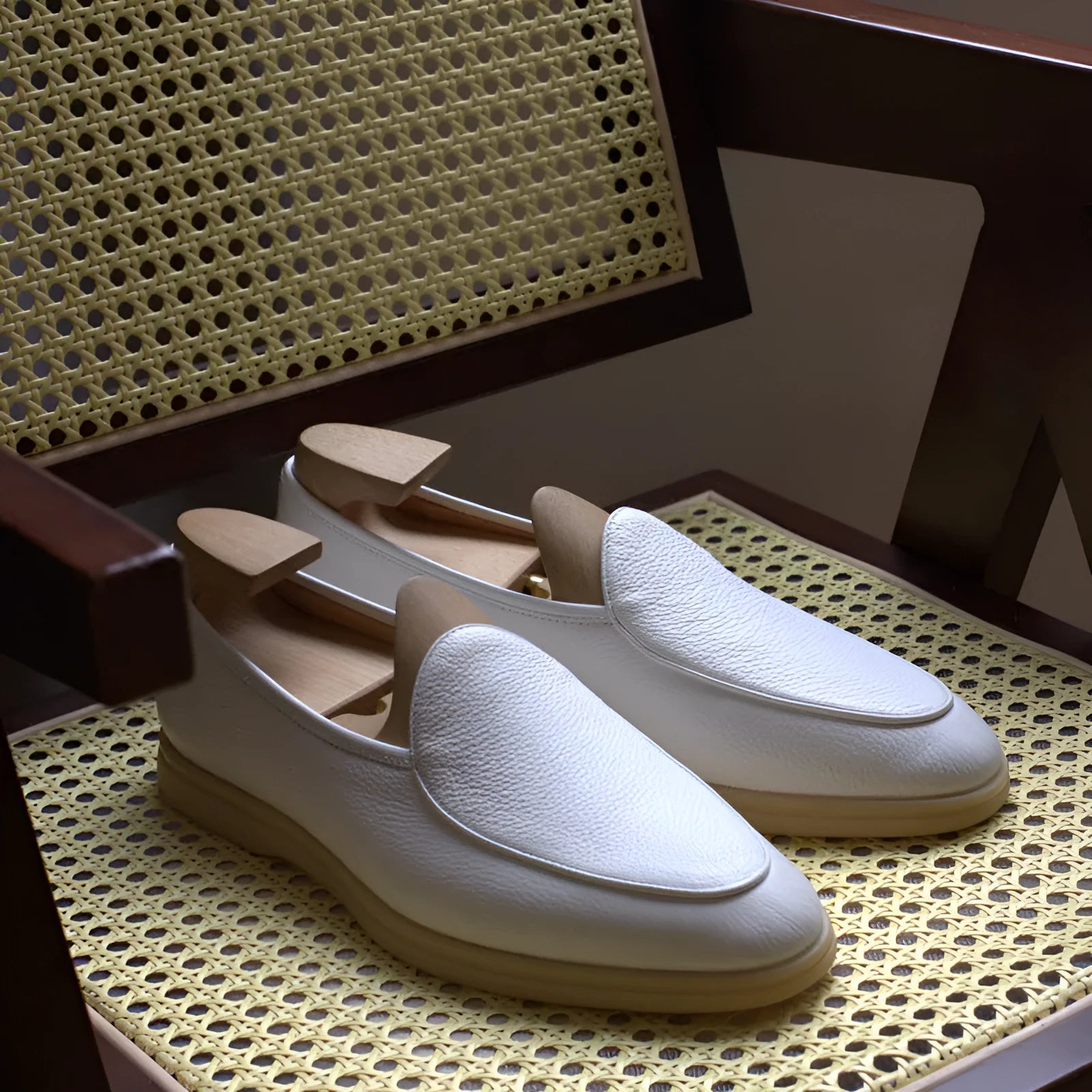Men's brown genuine leather handmade loafers on a white background, showing the low-cut slip-on design and textured sole.